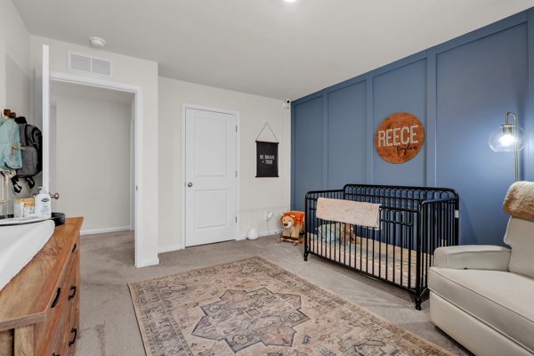A finished nursery with a deep blue board-and-batten accent wall